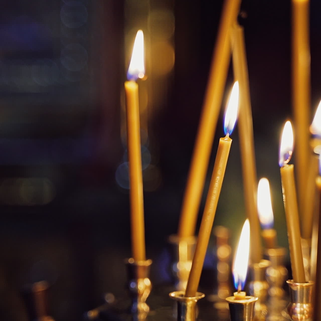 Bright wax candles burning in church. Abstract candles background. Golden light of candle flame. Candles light.