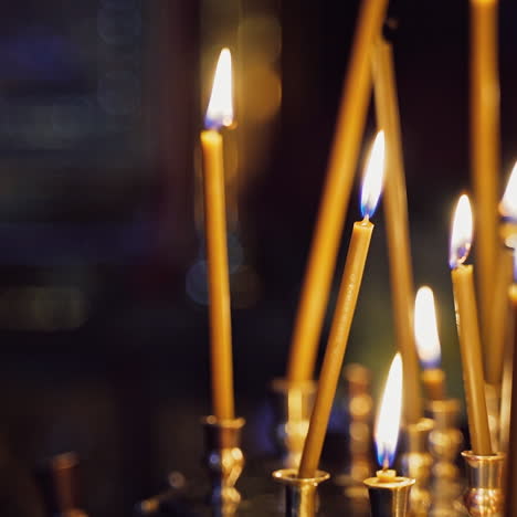 bright wax candles burning in church. abstract candles background. golden light of candle flame. candles light.