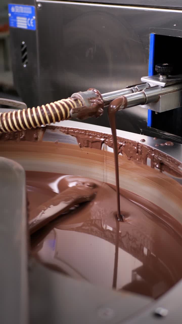 Chocolate mixer machine mixing and melting chocolate. Production of chocolate products in a Chocolate factory.