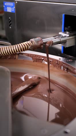 chocolate mixer machine mixing and melting chocolate. production of chocolate products in a chocolate factory.