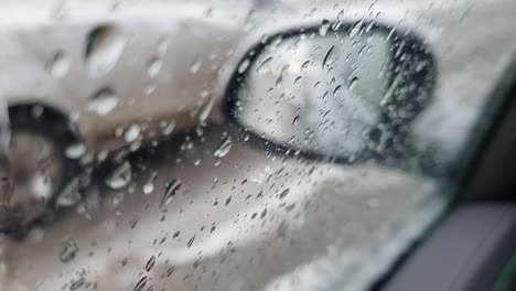 rainy day in a car. rain drops flowing down on a car window and other cars passing by