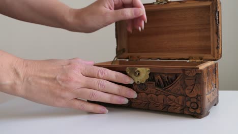 woman opening jewelry box and taking out vintage necklace, close up