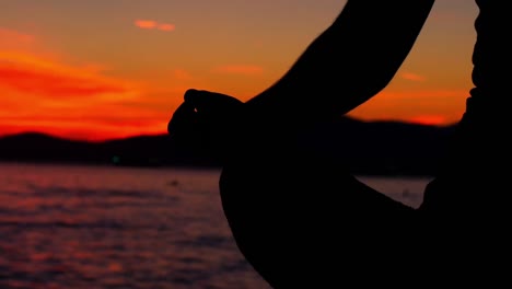 mujer realizando yoga en la playa