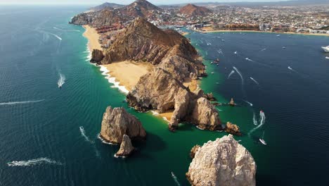 Aerial-view-overlooking-the-rocky-arch-of-Cabo-San-Lucas,-sunny-Mexico---tilt,-drone-shot