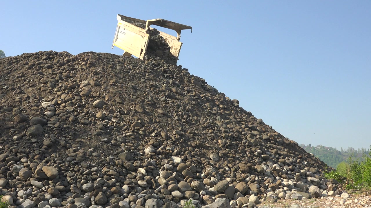Caminhão Basculante Descarregando Pedras em uma Grande Pilha