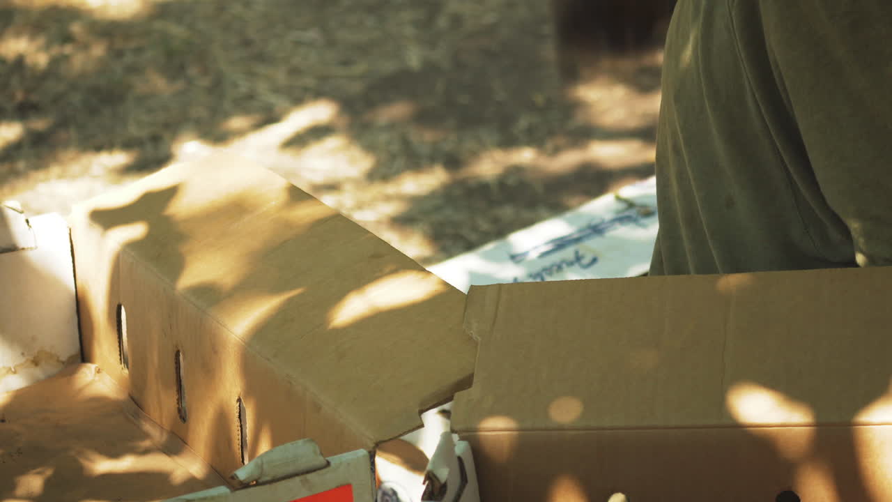 неузнаваемый мужчина организует картонные коробки