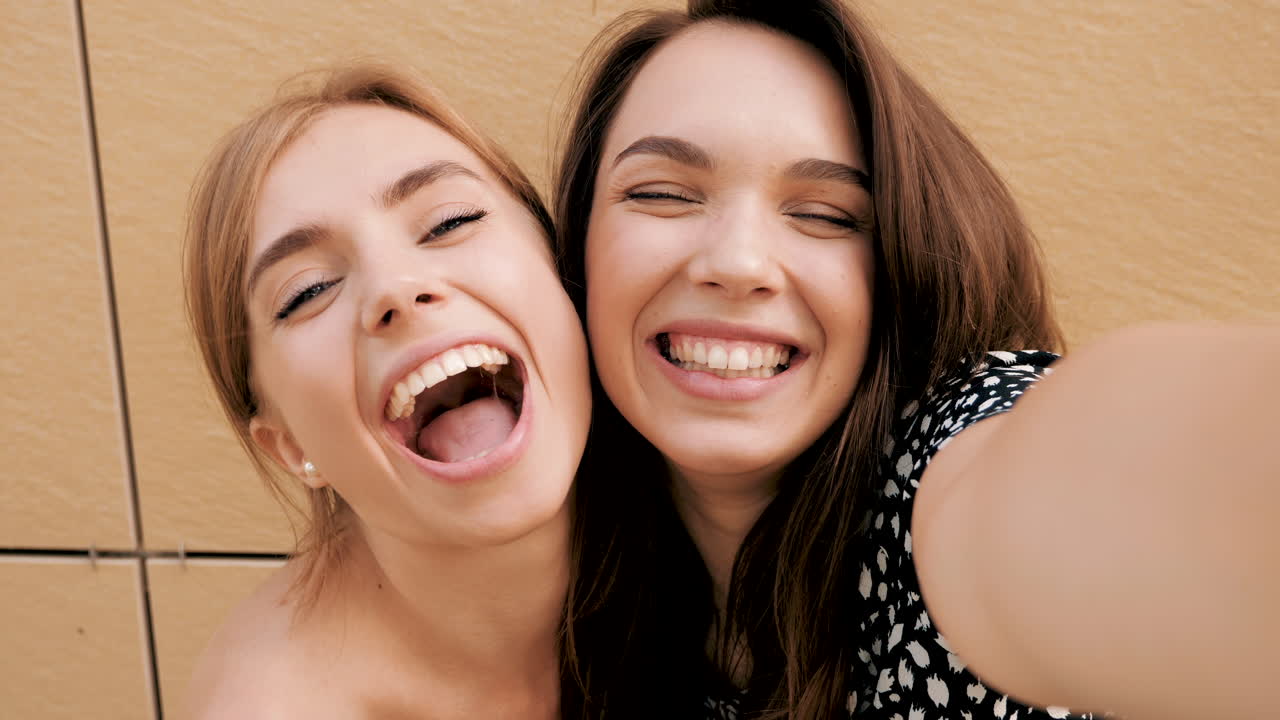 dos amigos felices tomando una selfie