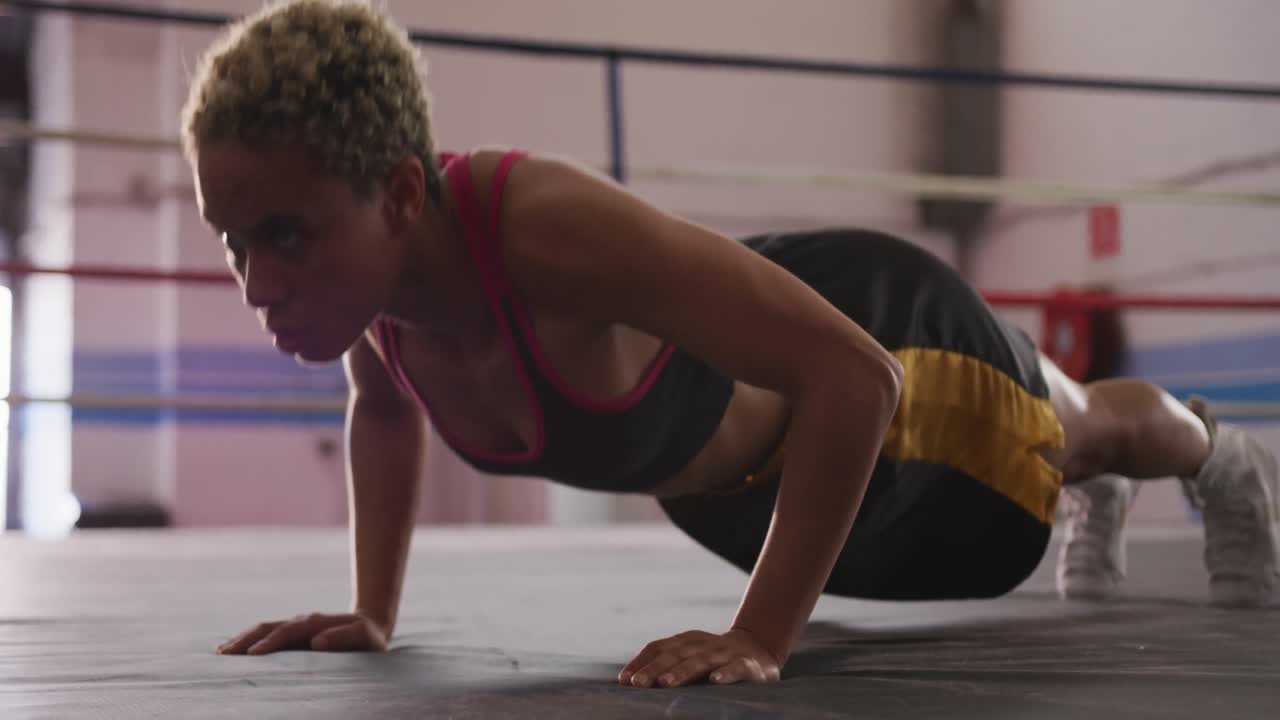 mujer de raza mixta trabajando en el gimnasio de boxeo