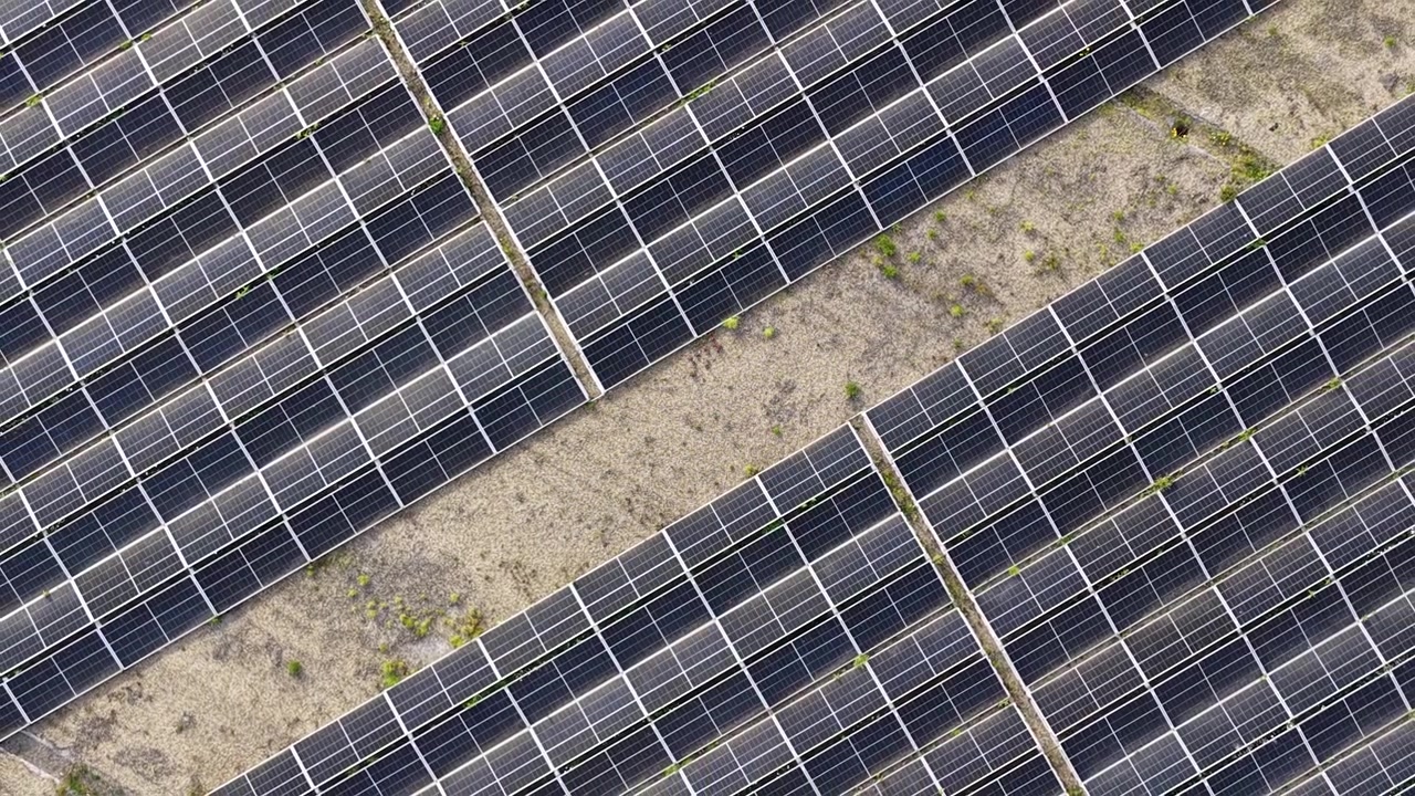 Infinite file di pannelli fotovoltaici in un parco solare, che convertono la luce solare in elettricità sostenibile e pulita per un futuro più verde, rappresentando un'innovazione chiave nella tecnologia delle energie rinnovabili