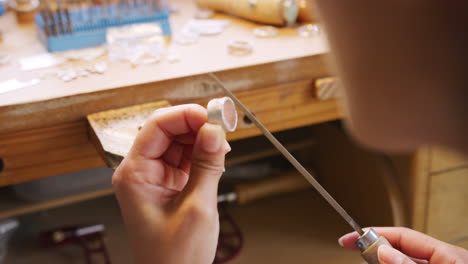 Close-Up-Of-Female-Jeweller-Working-On-Ring-With-File-In-Studio