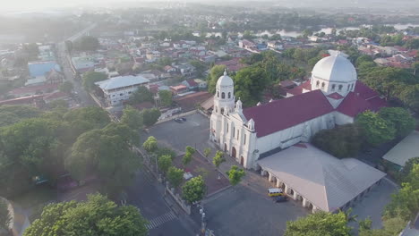 Un-Paisaje-Majestuoso-Y-Resplandeciente-Vista-De-Drones-De-Una-Iglesia-Basílica-De-La-Ciudad-Que-Tiene-Río-Y-Montañas,-Batangas,-Filipinas