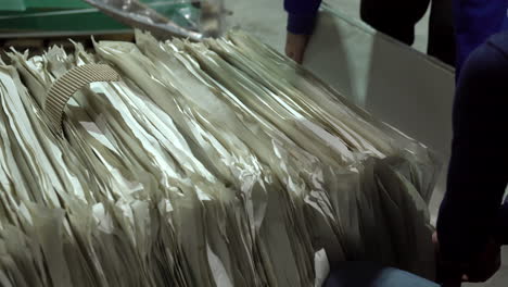 two workers are stacking glass products packed and wrapped in paper cardboard