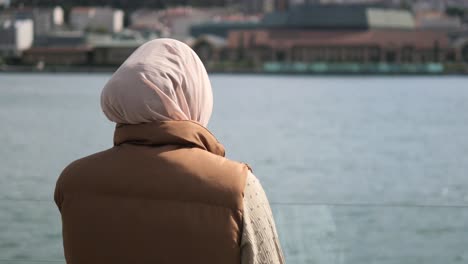 woman in hijab looking out at the city