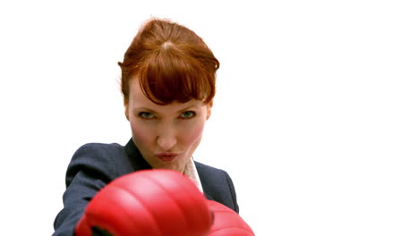 joven mujer de negocios golpeando con guantes de boxeo