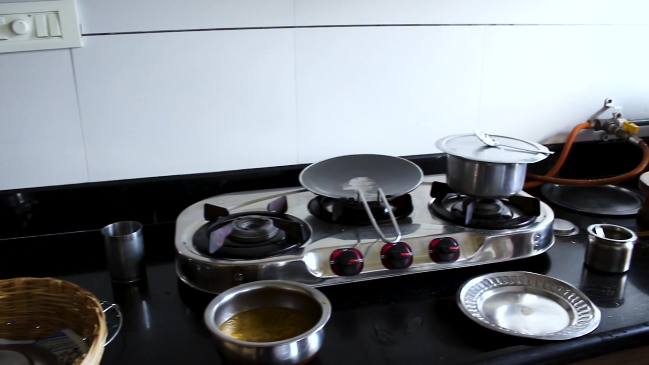 Realistic home kitchen scene after cooking with used cookware, gas stove, utensils, and food preparation items. Ideal for domestic lifestyle, household routine, and cleanup concepts.
