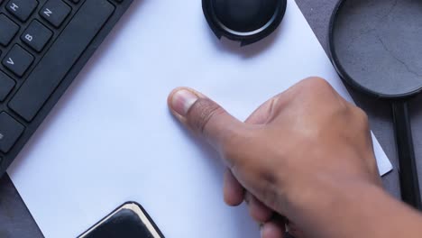 fingerprint analysis: close-up of thumbprint on paper with forensic tools