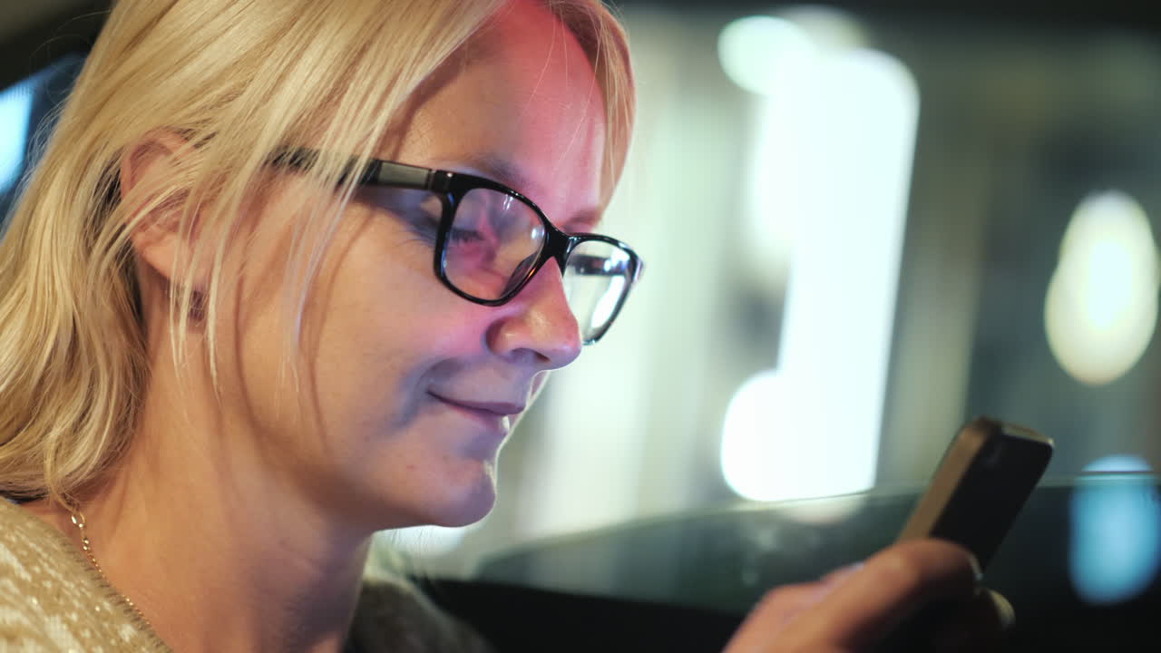 mujer enviando mensajes de texto en el coche por la noche
