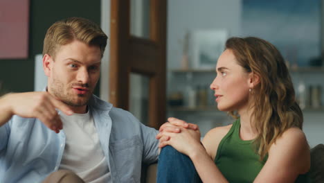 hombre contando una historia a su esposa hogar emocional primer plano. amantes serios hablando sofá