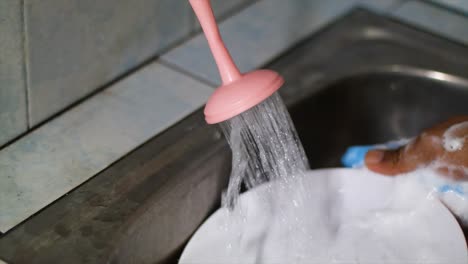 asian hands washing dishes using foam sponges