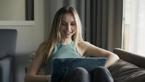 woman on sofa at home making video call using laptop on self isolation