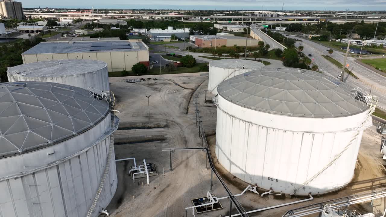 Vista aérea de una instalación industrial en Tampa, Florida, con grandes tanques de almacenamiento, tuberías y carreteras cercanas en condiciones de luz diurna clara en Estados Unidos. Plano general