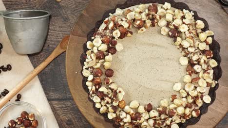 a delicious dessert, coffee hazelnut cream tart. made with espresso powder, chocolate crust and loaded with crushed hazelnuts. great with coffee. adding hazelnuts being added to the top of the pie