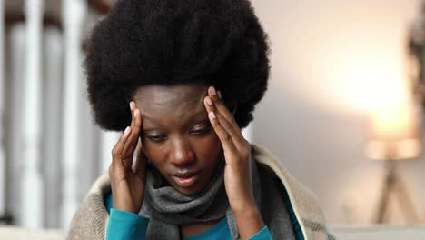 close up portrait of beautiful african american woman having headache at home