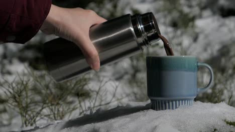 hot chocolate pouring into mug snowy winter forest, hot cocoa cup in snow