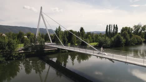 one person walking on pedestrian bridge over river tamega, chaves in portugal