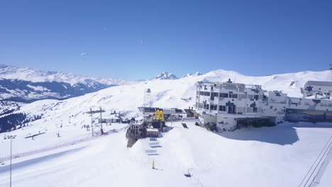 Pull-back-shot-of-upper-cable-car-station-and-restaurant.-Revealing-winter-mountain-landscape.-sunny-day-with-clear-sky.-Laax,-Switzerland