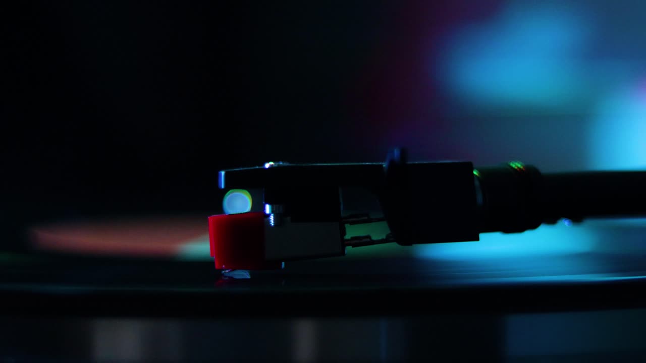 aguja del reproductor de grabación cerca girando con luces de colores