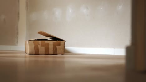 open cardboard box on a floor in an unfinished room