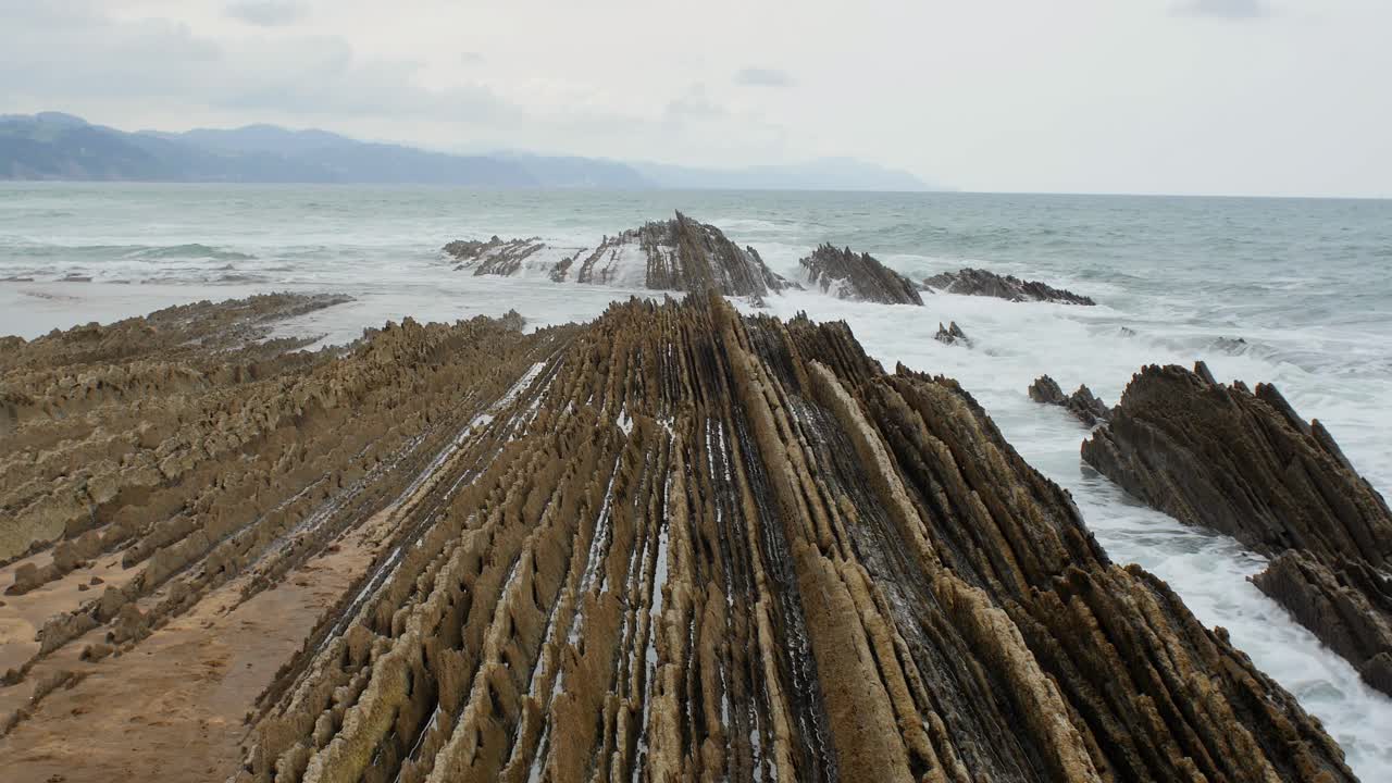 vista estática de estratos rocosos continuos, playa de itzurun zumaia españa