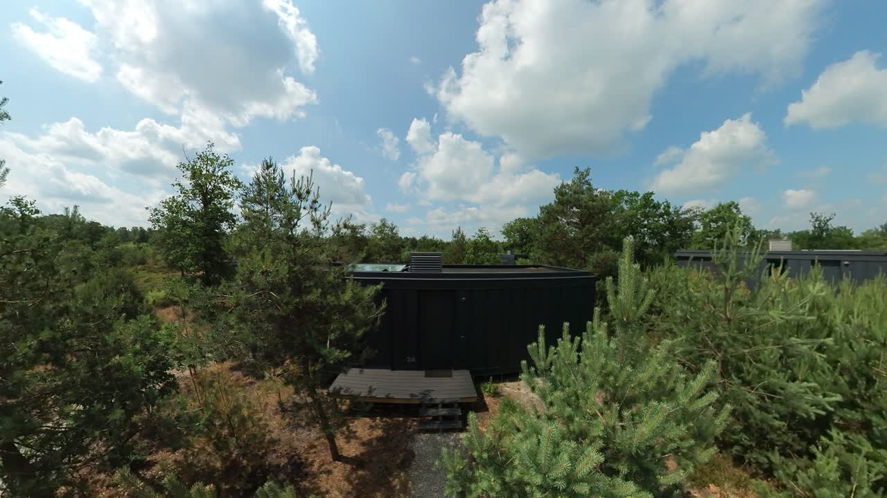 Modern Black Cylindrical Cabin in a Forest Retreat