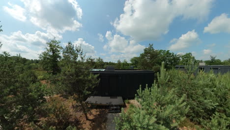 modern black cylindrical cabin in a forest retreat