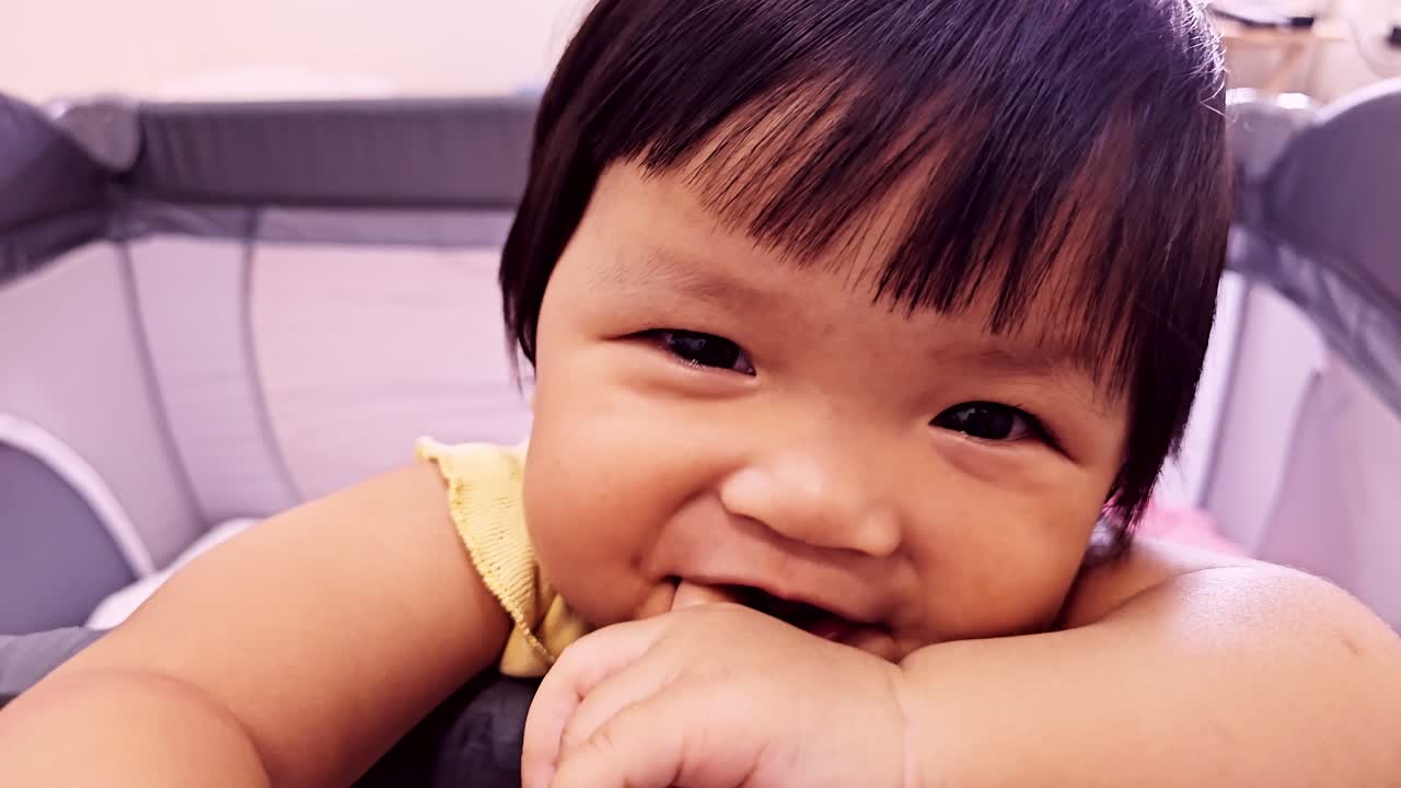 A charming baby showcasing curiosity and playfulness in a bright indoor environment.