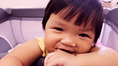 a charming baby showcasing curiosity and playfulness in a bright indoor environment.