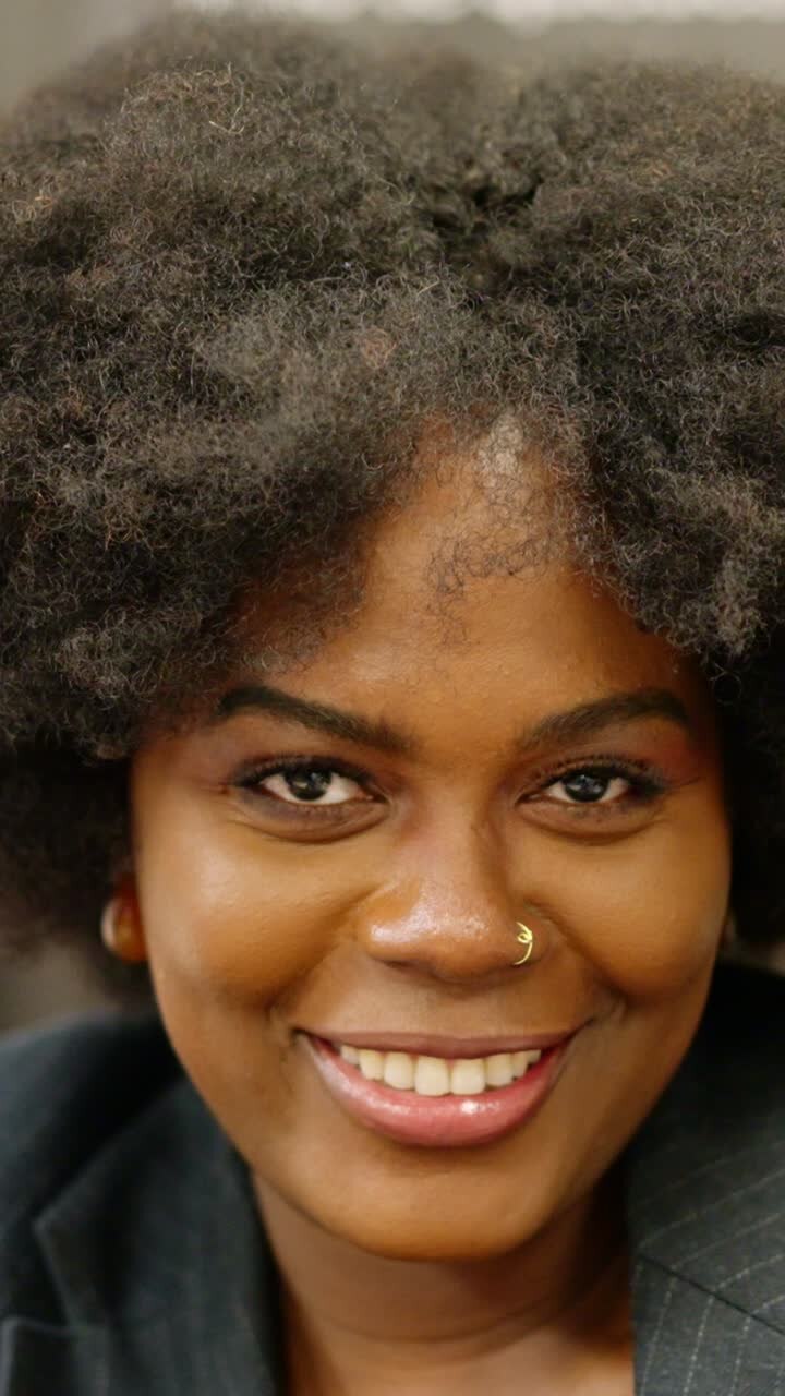 Close-up of african businesswoman smiling at camera in coworking