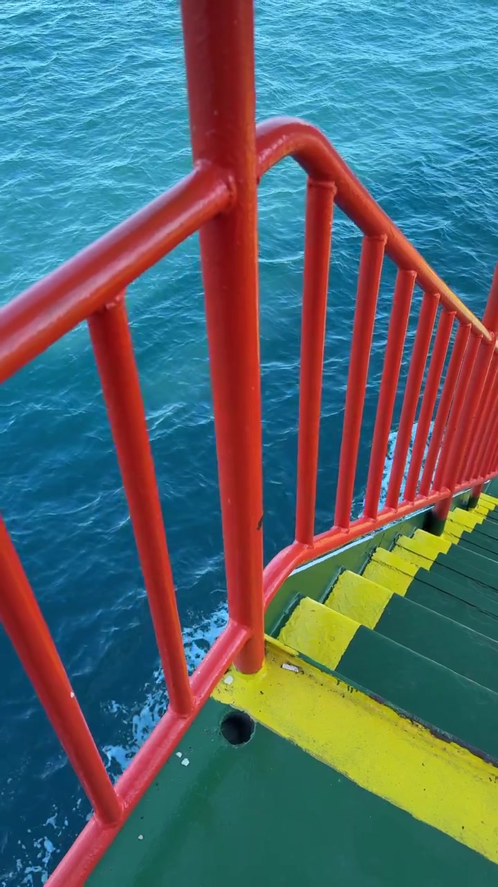 Malerische Aussicht von einem fahrenden Boot mit roter Reling und blauem Meer