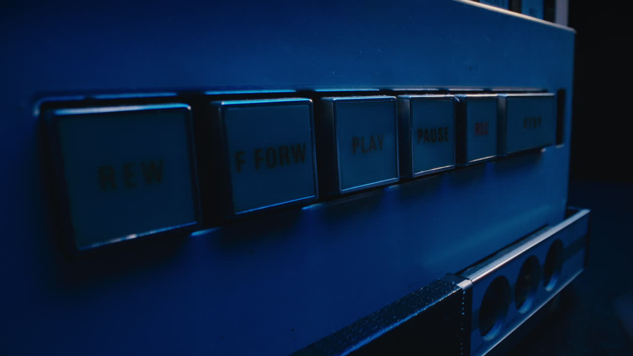 A close-up on a vintage tape recorder in a blue light