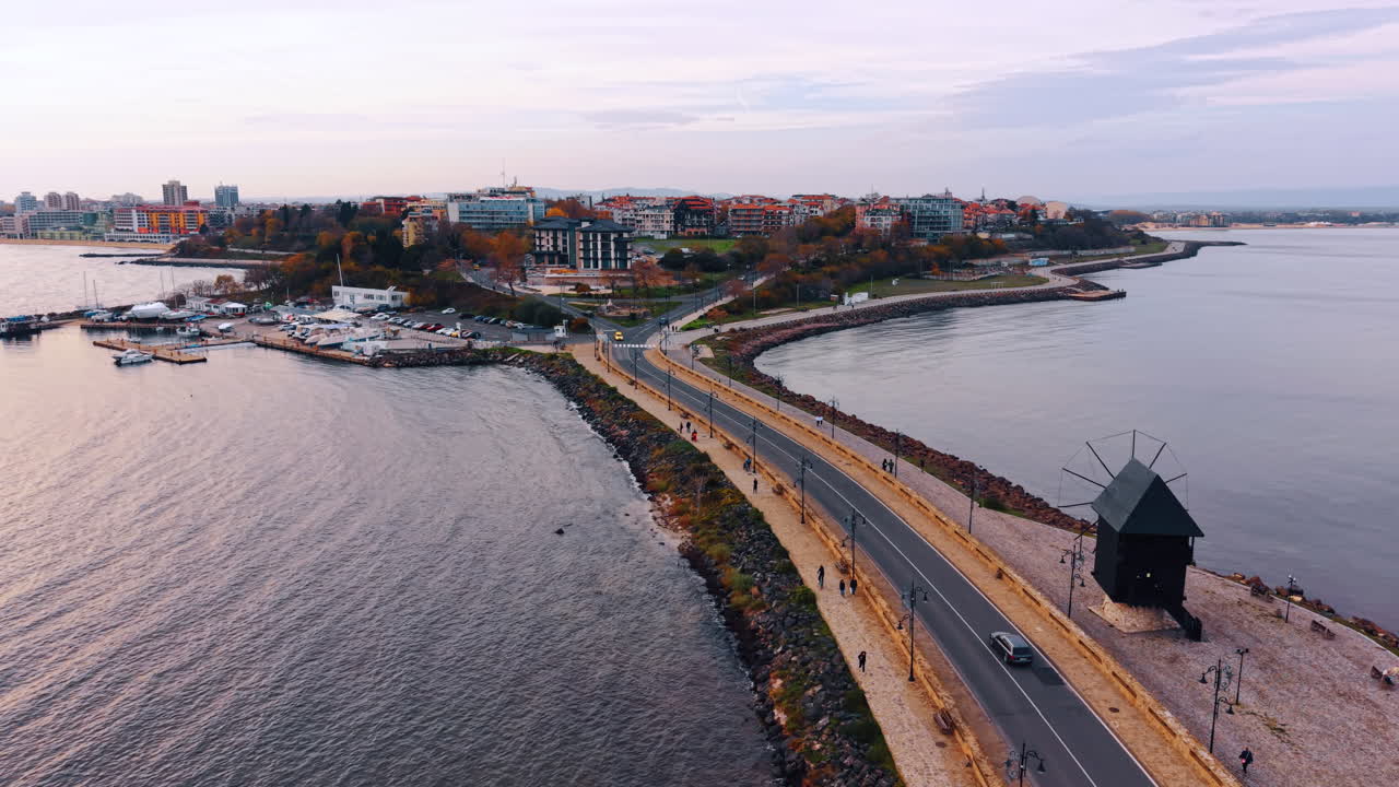 Seguendo l'auto che viaggia lungo la diga verso la bellissima città circondata dal paesaggio marino. Avvicinandosi al molo con barche e yacht. Nessebar, Bulgaria.