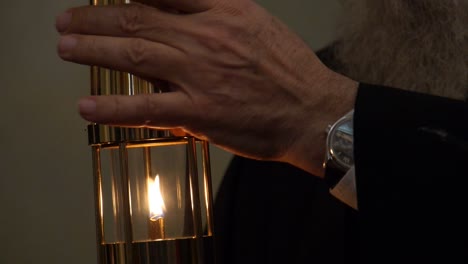 close-up of a priest holding a lit lantern for transfer of holy fire on easter at the church of holy sepulchre