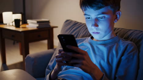 adolescente usando el teléfono inteligente por la noche