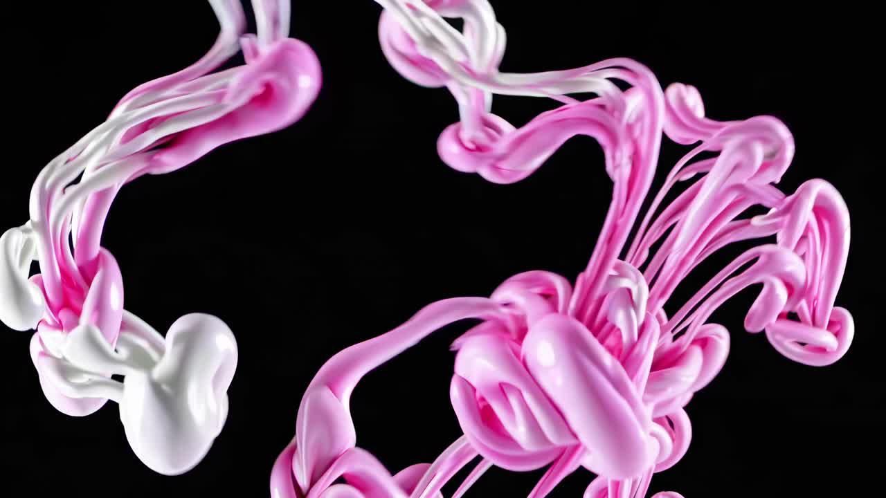 Abstract video of pink and white paint swirling in mid-air against a black background