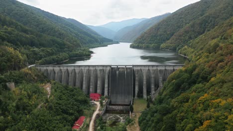 very big dam, sea or reservoir in a beautiful valley between a big forest, carpathians, romania, europe, drone, summer