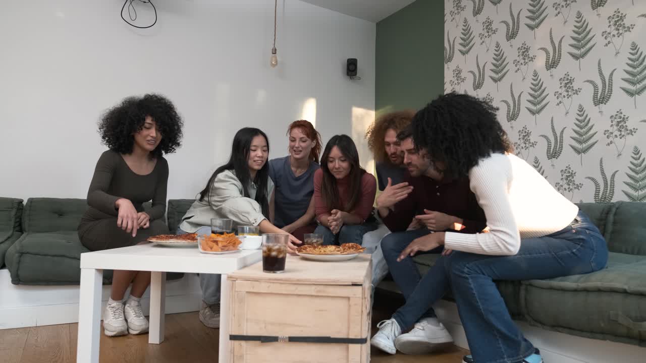 Diverse friends cheering up for woman bringing pizzas during weekend party at home