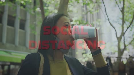 animation of social distancing text over woman drinking takeaway coffee in city wearing face mask