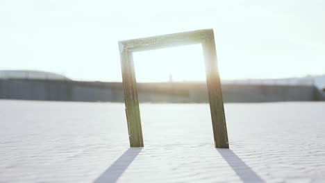 Empty-wooden-picture-frame-on-the-beach-sand