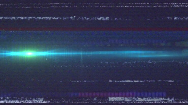 Animation of vhs glitch effect over green light spot moving against blue background