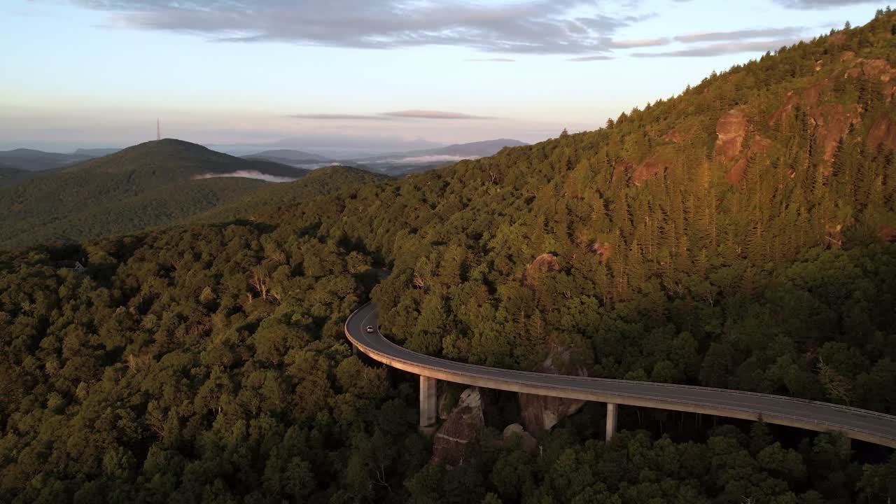 coche en el viaducto hacia el oeste al amanecer debajo de la montaña del abuelo nc